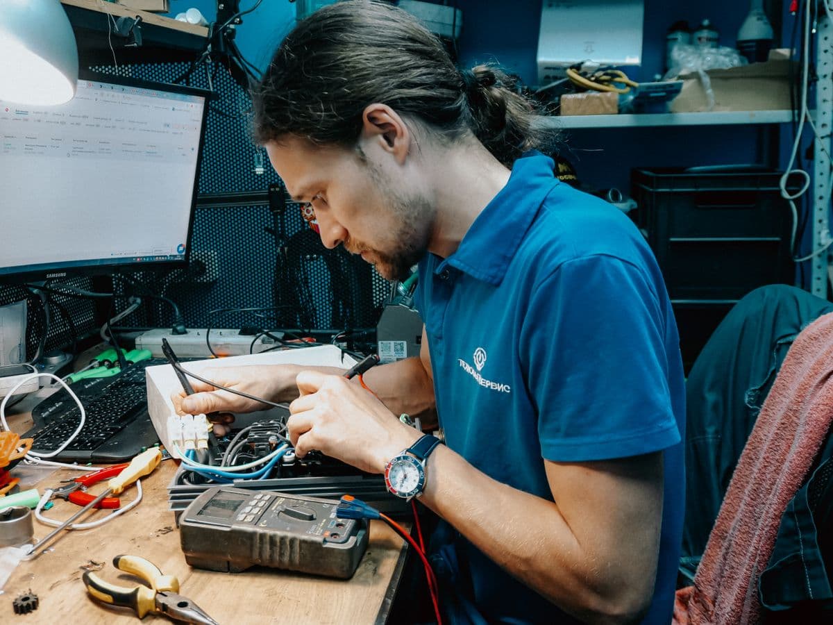 IT technician testing equipment with a multimeter