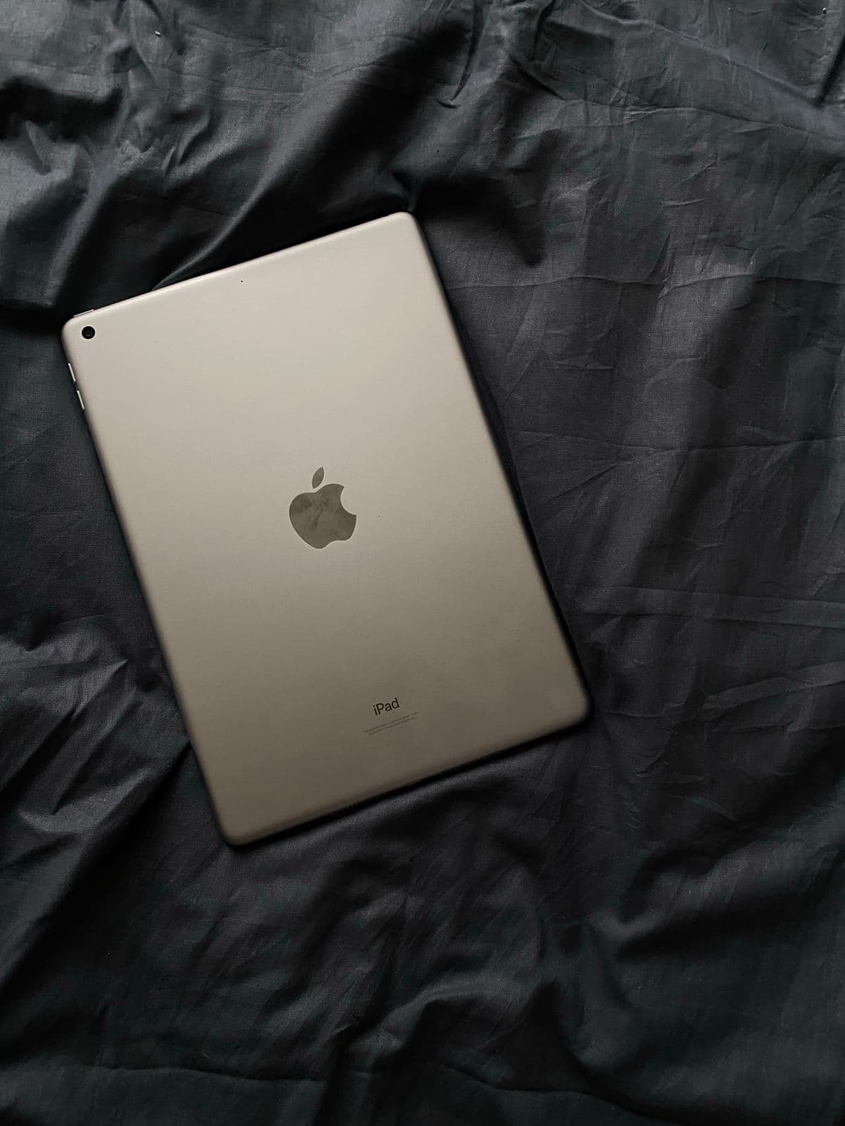 Apple iPad resting on dark fabric